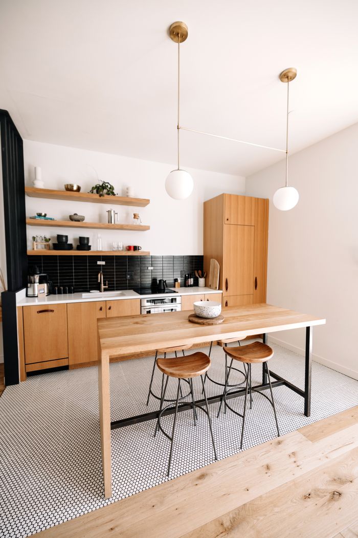 Bright minimalist kitchen with wooden furnishings and modern decor.