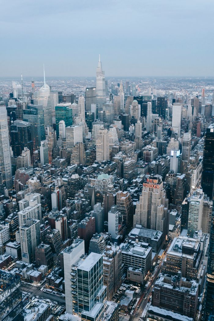 A breathtaking aerial shot of New York City with snow-covered skyscrapers and a clear skyline, capturing urban winter beauty.